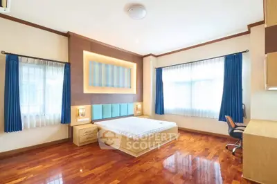 Spacious bedroom with wooden flooring and modern decor