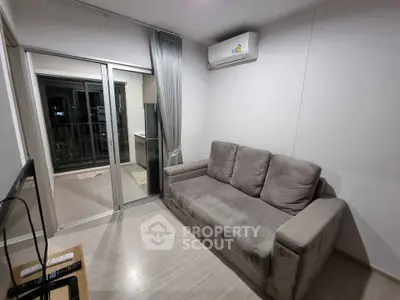 Modern living room with cozy sofa and air conditioning, featuring a balcony view.