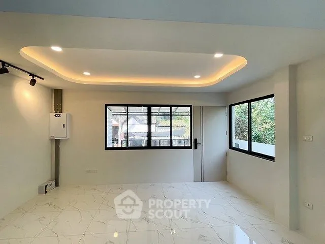 Spacious modern living room with large windows and elegant ceiling lights