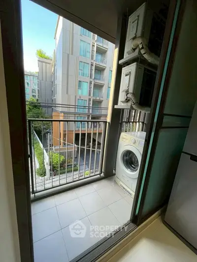 Modern apartment balcony with washing machine and city view.