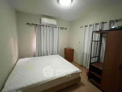 Cozy bedroom with natural light, featuring a comfortable bed and ample storage space.