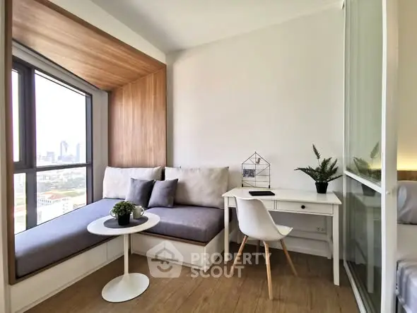 Chic modern study nook with city view and cozy seating in stylish apartment.