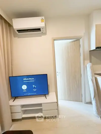 Modern living room with air conditioning and flat-screen TV, featuring minimalist furniture and light wood accents.