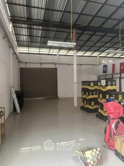 Spacious warehouse interior with tiled flooring and high ceiling, ideal for storage or commercial use.