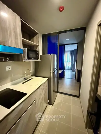 Modern kitchen with sleek cabinetry and stainless steel appliances in a stylish apartment.