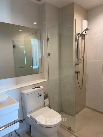 Modern bathroom with glass shower and sleek fixtures in a contemporary apartment.