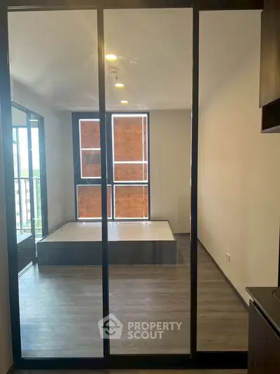 Modern bedroom with large windows and sleek flooring in a contemporary apartment.