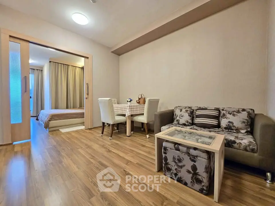 Modern open-plan living room with stylish decor and cozy bedroom view.