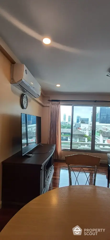 Spacious living room with city view and modern amenities in high-rise apartment.