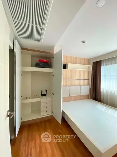 Modern bedroom with built-in storage and sleek wooden flooring