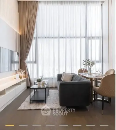 Luxurious high-ceiling living room with elegant decor and large windows.