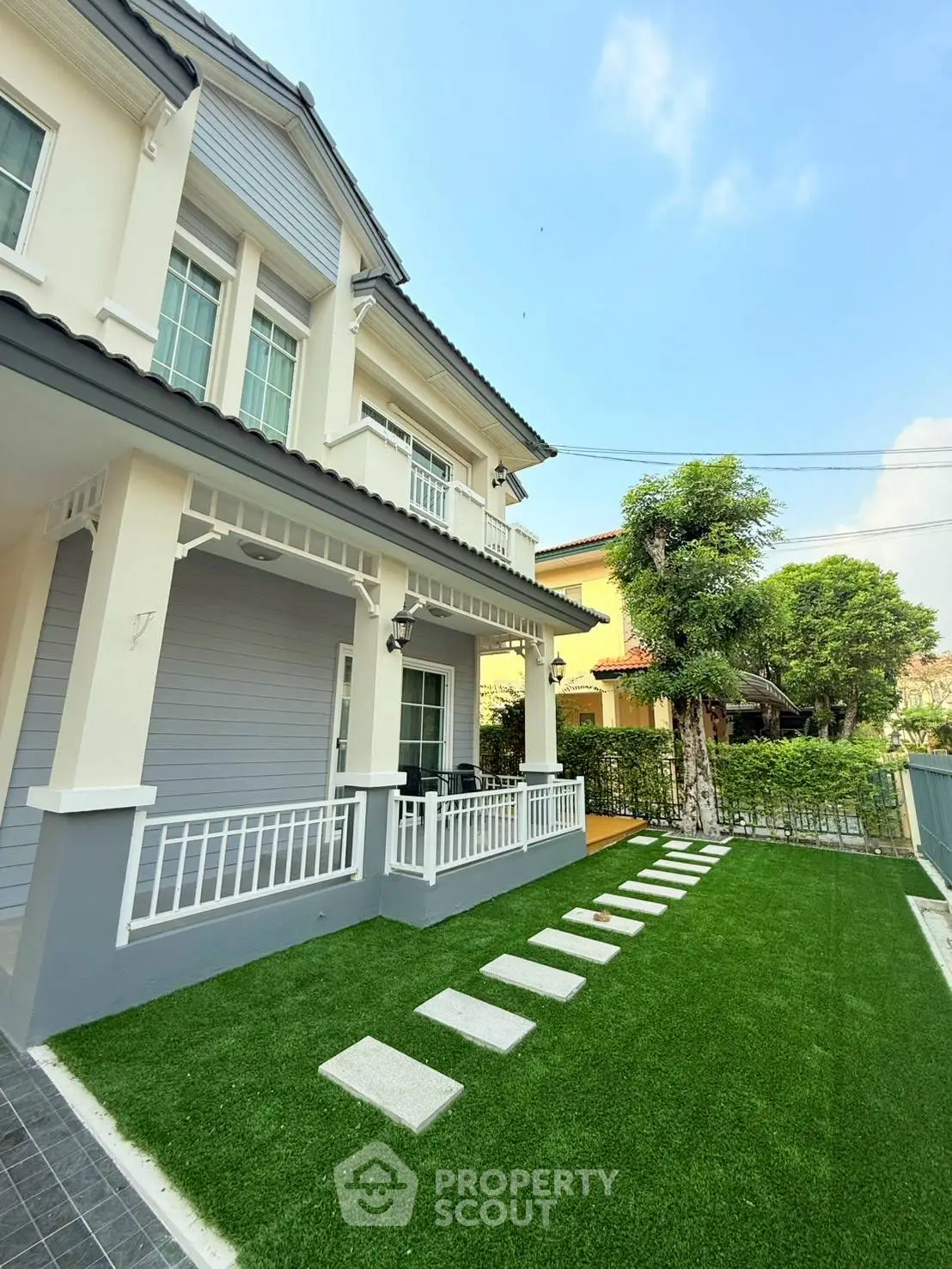 Charming two-story house with manicured lawn and modern exterior design in a serene neighborhood.