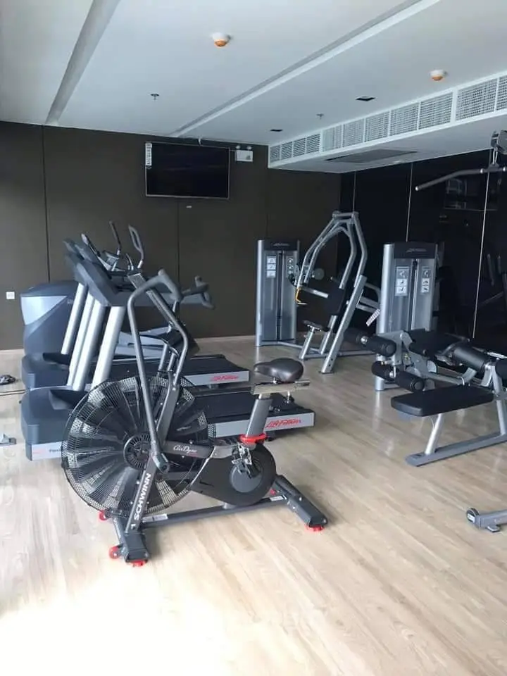 Modern gym with state-of-the-art fitness equipment and sleek wooden flooring.