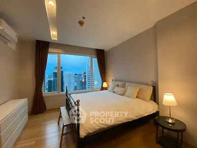 Spacious bedroom with city view, featuring a large bed and modern decor, perfect for urban living.