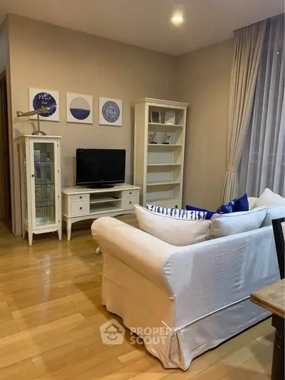 Charming living room with elegant white furniture and cozy decor.