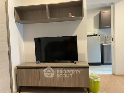 Modern living room with sleek TV stand and open kitchen view, perfect for contemporary living.