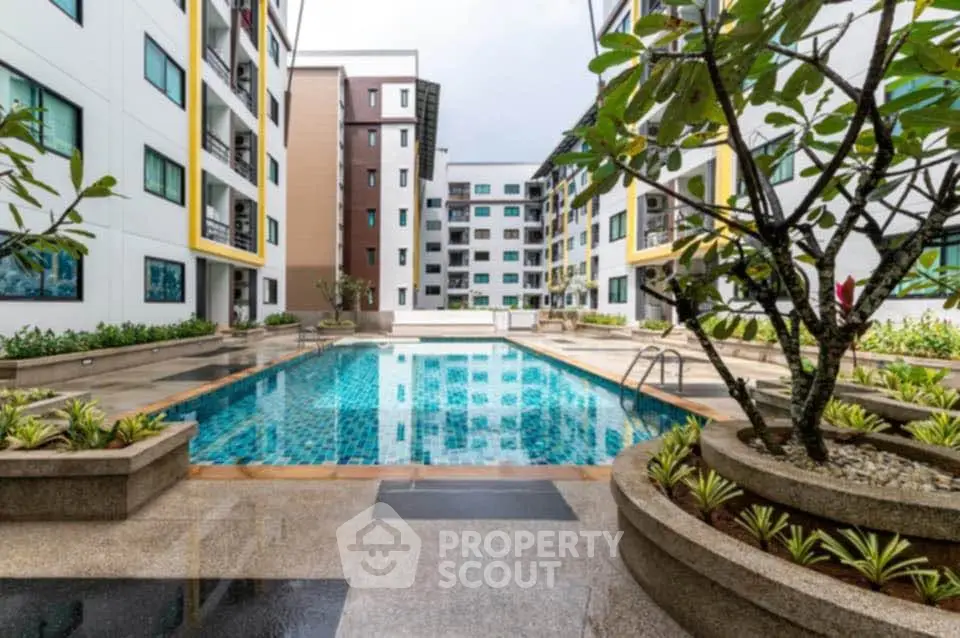 Modern apartment complex with inviting outdoor pool and lush landscaping.