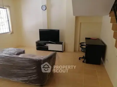 Cozy living room with TV and sofa, perfect for relaxation.