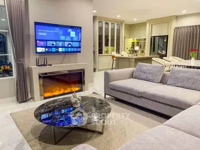 Luxurious living room with modern fireplace and open kitchen layout, perfect for entertaining.