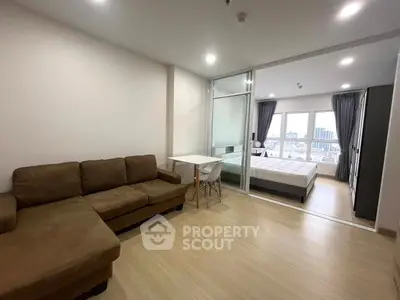 Modern studio apartment with open layout, featuring a cozy living area and a bright bedroom with city views.