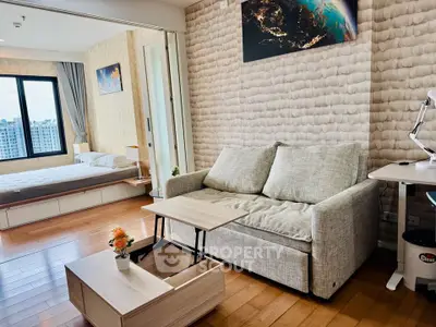 Modern studio apartment with cozy living area and bedroom, featuring stylish decor and city view.