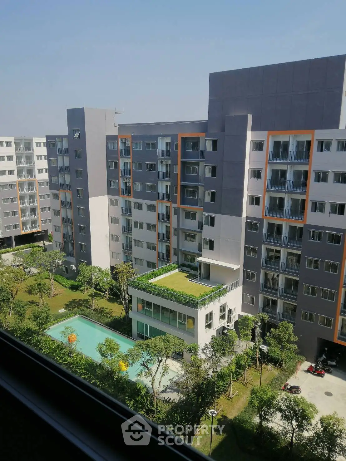 Modern apartment complex with pool and garden view, showcasing urban living at its finest.