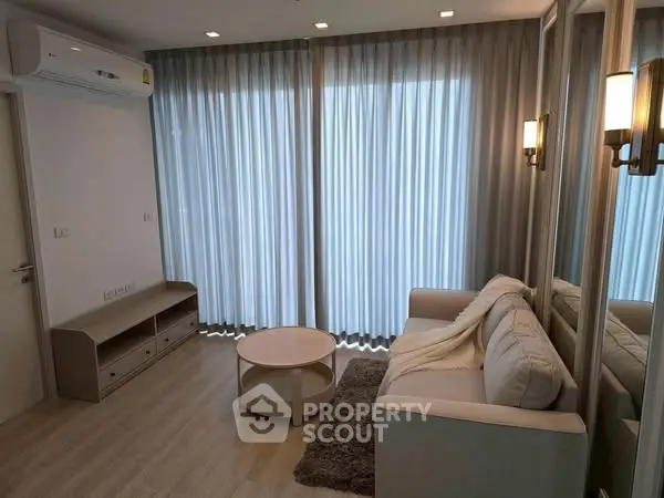 Modern living room with cozy sofa, stylish lighting, and floor-to-ceiling curtains in a chic apartment.