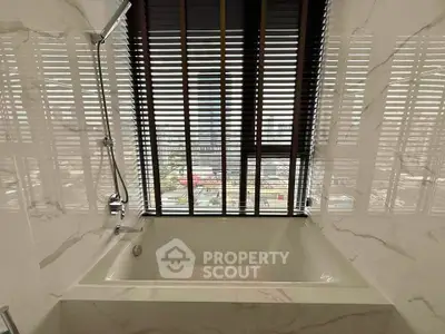 Luxurious bathroom with marble walls and city view from large window