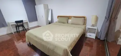 Spacious bedroom with elegant decor and hardwood flooring, featuring a comfortable bed and modern furnishings.