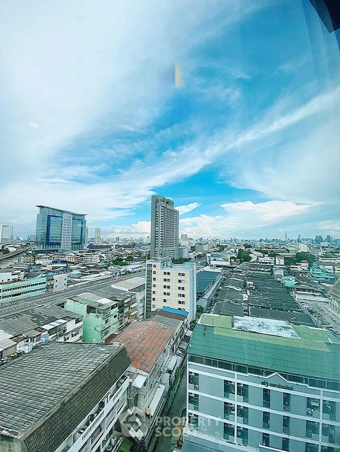 Stunning cityscape view from high-rise building showcasing urban skyline and clear blue sky.