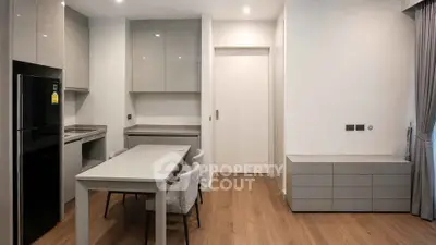 Modern kitchen with sleek cabinetry and dining area in contemporary apartment
