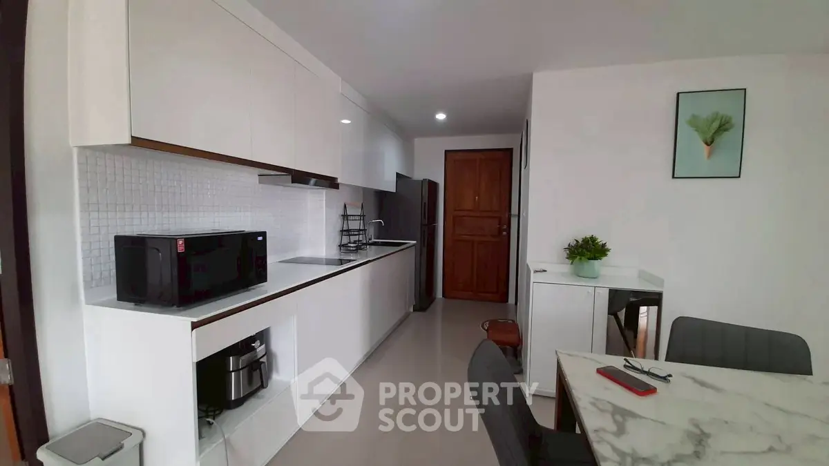 Modern kitchen with sleek white cabinets and marble dining table