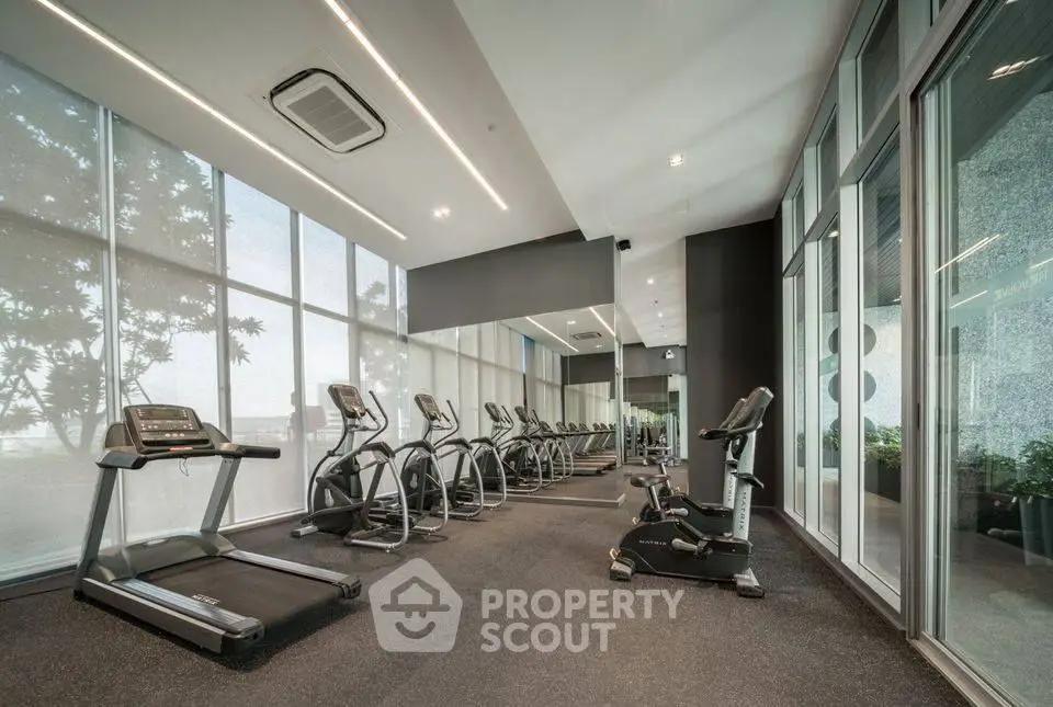 Modern gym with state-of-the-art equipment and large windows for natural light.