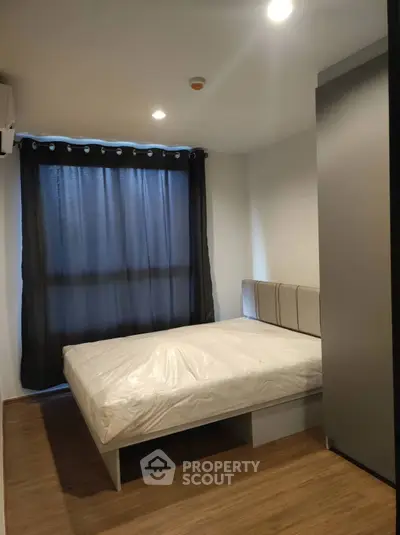 Cozy modern bedroom with wooden flooring and stylish curtains