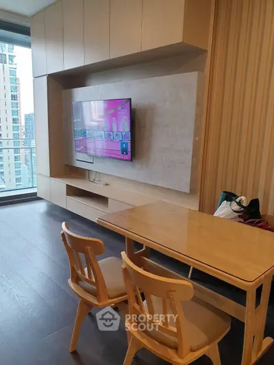 Modern living room with sleek wooden furniture and wall-mounted TV in a high-rise apartment.