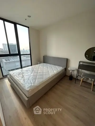 Modern bedroom with large window and stylish furniture in urban apartment