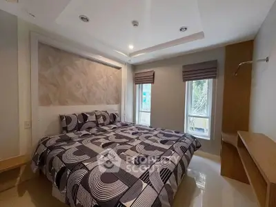 Modern bedroom with stylish decor and large windows in a contemporary apartment.