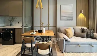Modern living room with stylish decor, cozy sofa, dining table, and integrated kitchen appliances.