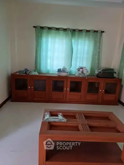 Spacious room with wooden cabinets and large windows, ideal for versatile use.