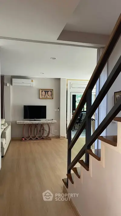 Modern living room with wooden flooring and stylish staircase