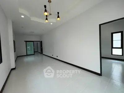 Spacious modern living room with elegant lighting and large windows in a contemporary home.