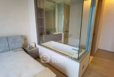 Modern bedroom with glass-enclosed bathtub and sleek design