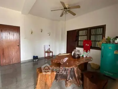 Charming rustic living room with unique wooden furniture and ceiling fan, perfect for cozy gatherings.
