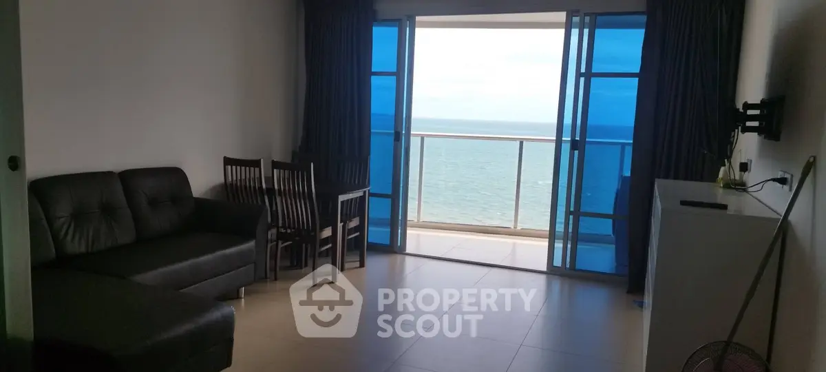 Stunning ocean view from modern living room with balcony access.