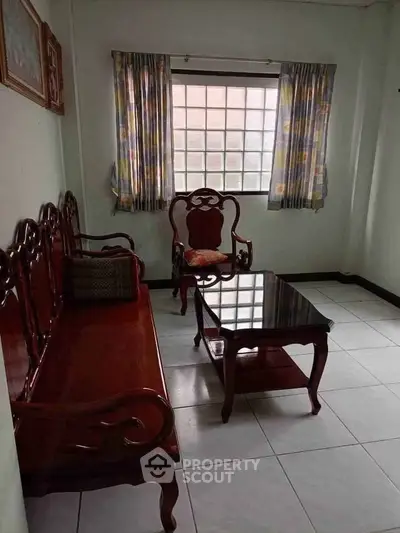 Charming living room with classic wooden furniture and large window for natural light.