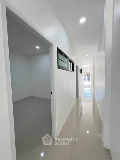 Sleek modern hallway with glossy floors and bright lighting in a contemporary home.