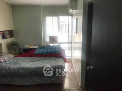 Cozy bedroom with natural light and air conditioning, perfect for relaxation.