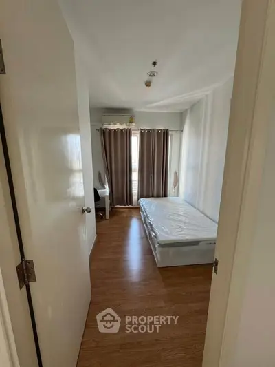 Cozy minimalist bedroom with wooden flooring and natural light