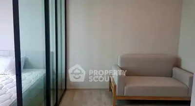 Modern apartment with cozy seating and glass partitioned bedroom