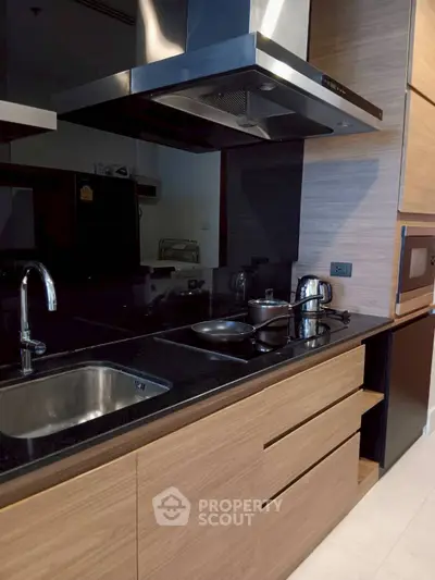 Modern kitchen with sleek black countertops and wooden cabinetry